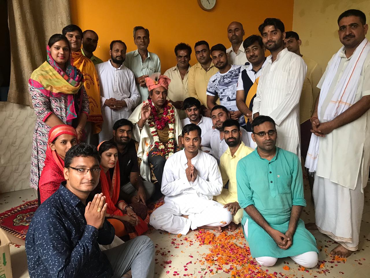 Guruji with devotees amid flower petals - Shreedham108